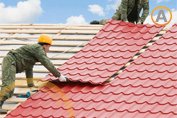 Personal de la construcción colocando galvatejas en el tejado de una vivienda